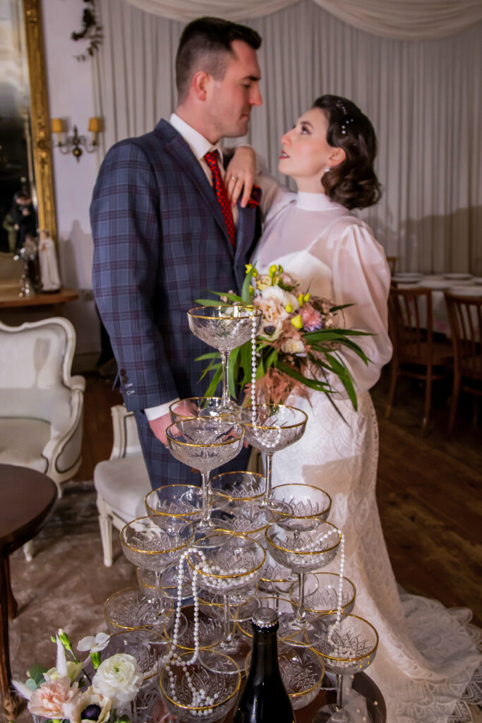 Diese elegante Sektpyramide, umrahmt von wunderschöner Hochzeitsdekoration, wurde während einer Hochzeit im Schwarzwald bei Sand von einem professionellen Hochzeitsfotografen aus Karlsruhe eingefangen. Die glitzernde Sektpyramide bildet einen festlichen Mittelpunkt der Feier und wird von sorgfältig ausgewählter Dekoration umgeben, die die natürliche Schönheit des Schwarzwaldes widerspiegelt. Die Details der Dekoration – von floralen Arrangements bis hin zu stimmungsvollen Lichtern – verleihen der Hochzeit eine romantische und stilvolle Atmosphäre. Diese wunderschönen Hochzeitsfotos fangen die festliche Stimmung und die magische Kulisse der Schwarzwaldhochzeit perfekt ein.