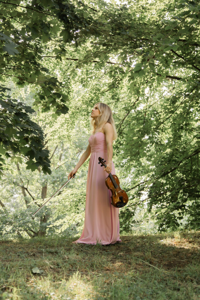 „Eine Violinistin spielt ihre Geige in der wunderschönen Natur rund um Karlsruhe und schafft eine romantische Atmosphäre, die perfekt für Hochzeiten und besondere Events ist.“